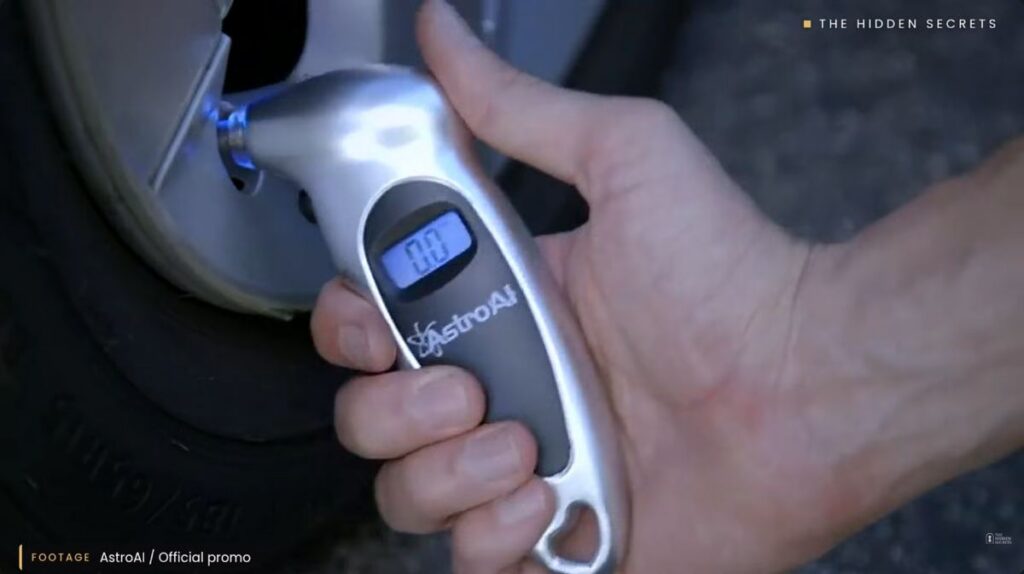 AstroAI digital tire pressure gauge checking a car tire